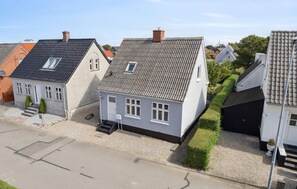 A row of white houses with grey tiled roofs, a gravel driveway, and a clear sky. - Gorgeous home in Bagenkop with WiFi (Bagenkop)