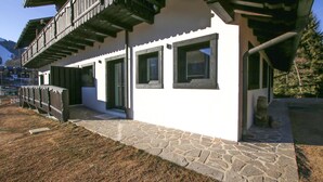 A two-story building with a stone foundation, wooden balconies, and large windows.