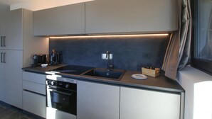 A modern kitchen with a built-in oven, a stovetop, and a sink.