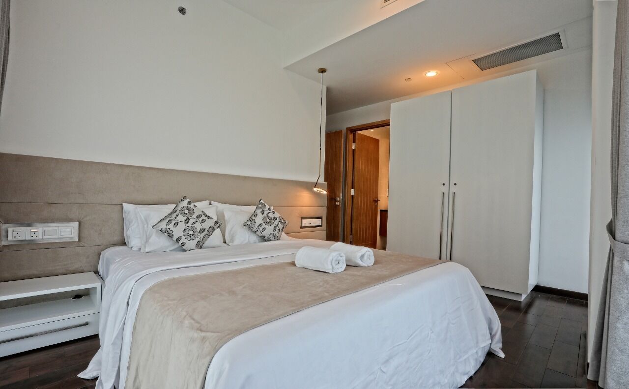 Ein Hotelzimmer mit einem großen Bett, einem Kleiderschrank und einem Nachttisch.