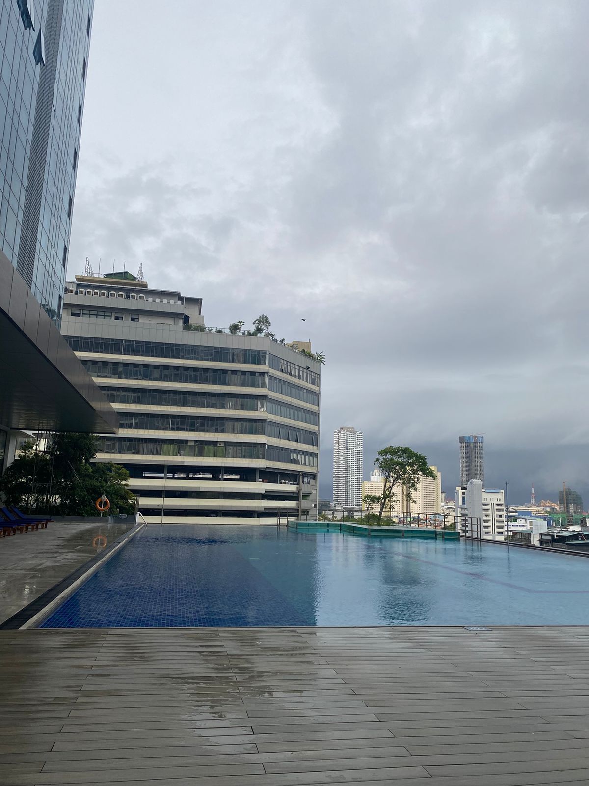Un bâtiment moderne doté d’une piscine, d’un espace couvert et offrant une vue sur le panorama urbain.