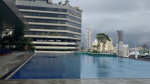 A modern building with a swimming pool, a covered area, and a view of the city skyline. - Twin Peaks Luxury 2-bedroom apartment with AC in tranquil Colombo (Colombo)