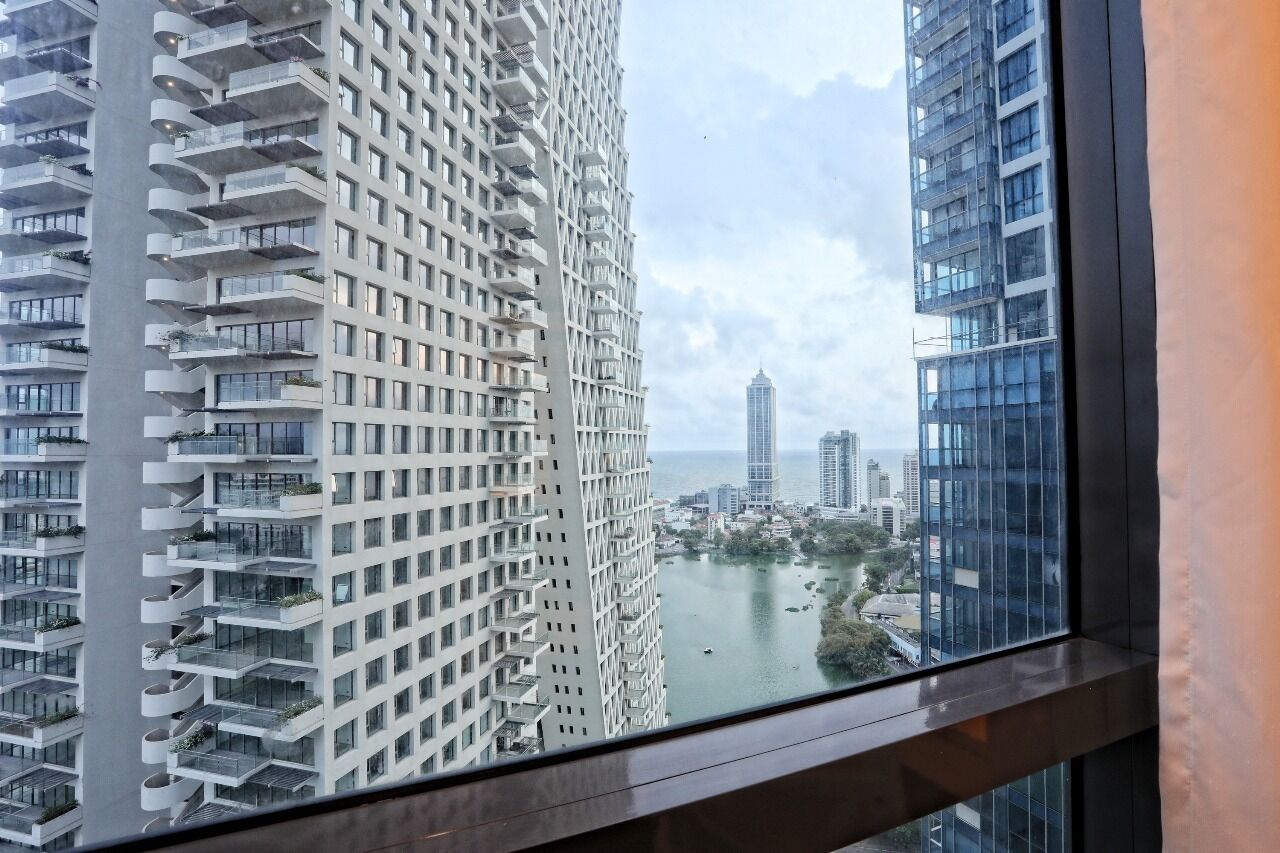Un immeuble de grande hauteur doté de nombreux balcons et offrant une vue sur le paysage urbain et une étendue d’eau.