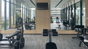 A modern gym with mirrored walls, large windows, and various exercise equipment. - Twin Peaks Luxury 2-bedroom apartment with AC in tranquil Colombo (Colombo)
