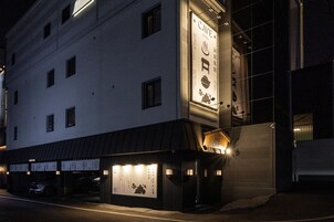 Un edificio con un letrero que dice 'Cave Hotel' y un estacionamiento al frente.
