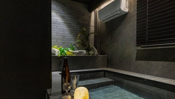 Un baño con una bañera, una botella, una ampulleta y una esfera brillante.