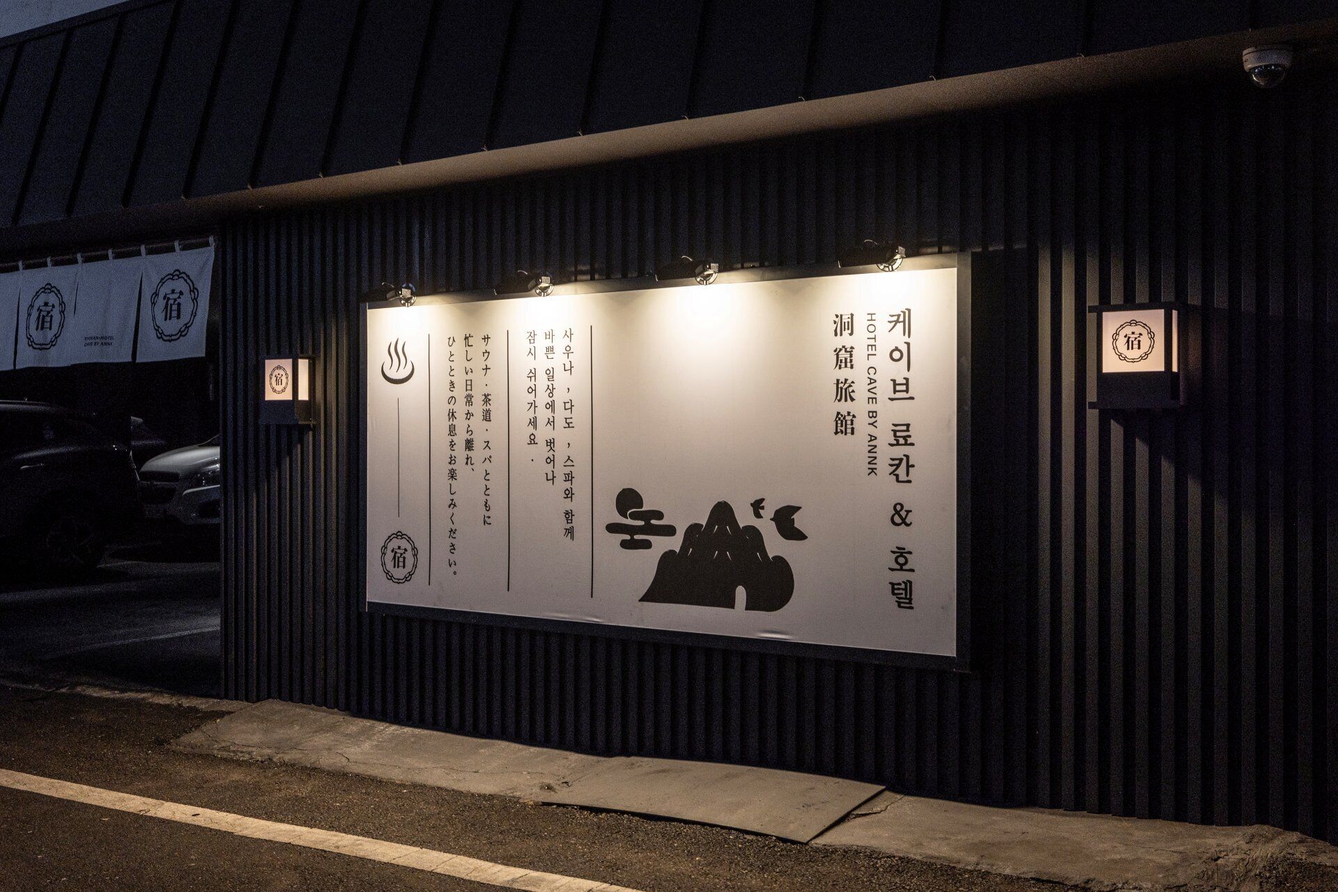 A building with a signboard displaying text and symbols, possibly indicating hotel or lodging information.
