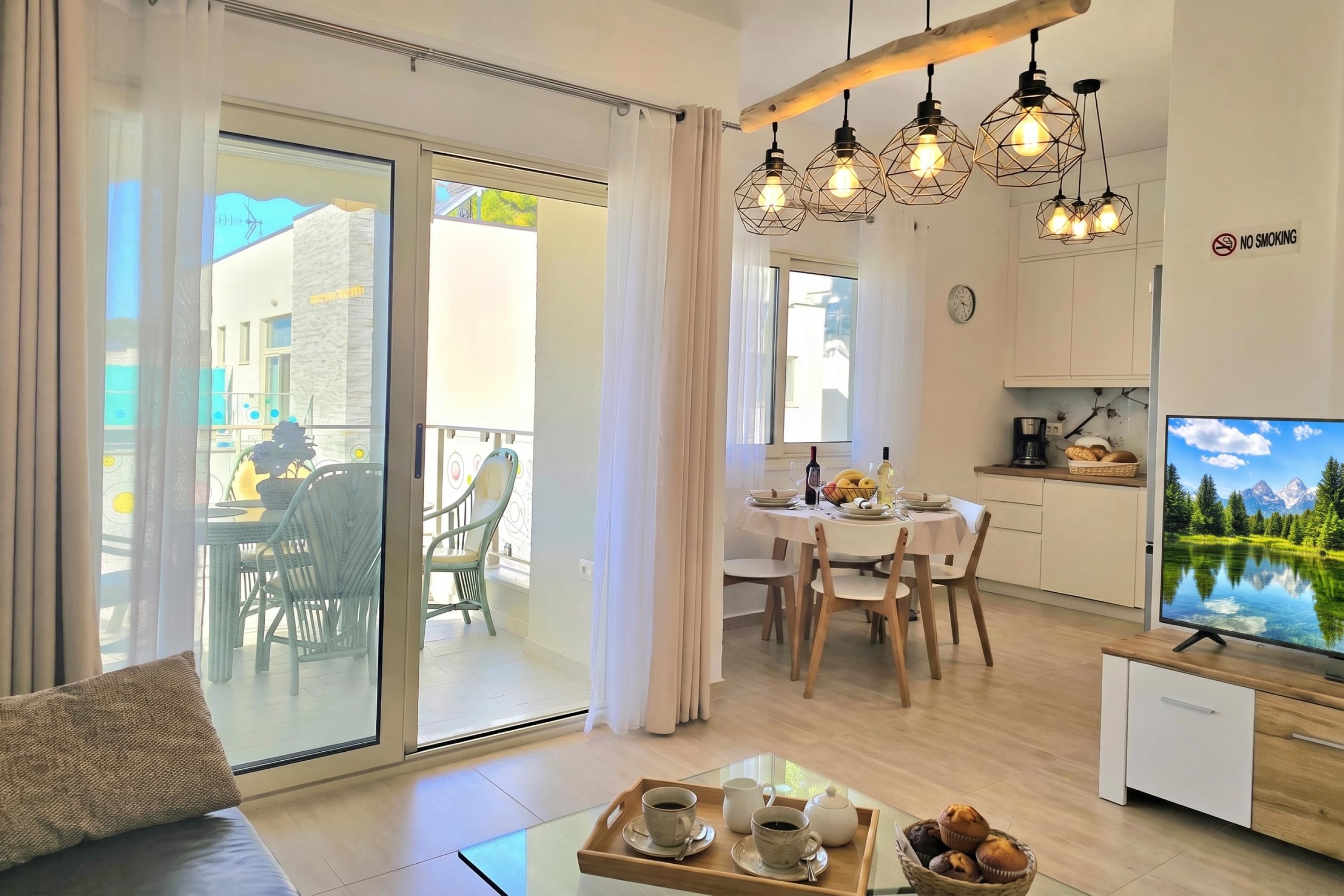 Eine moderne Wohnung mit Essbereich, Küche und einem Balkon mit Aussicht.
