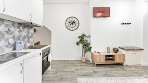 Eine moderne Küche mit weißen Schränken, einer gefliesten Spritzschutzwand und einem Holztisch.