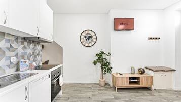 Eine moderne Küche mit weißen Schränken, einer gefliesten Spritzschutzwand und einem Holztisch.
