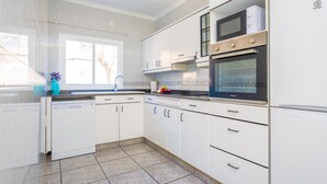 A modern kitchen with white cabinets, a built-in oven, and a microwave. - COSTA D'EN BLAU - House 2 minutes from Porto Cristo beach with free Wi-Fi (Manacor)