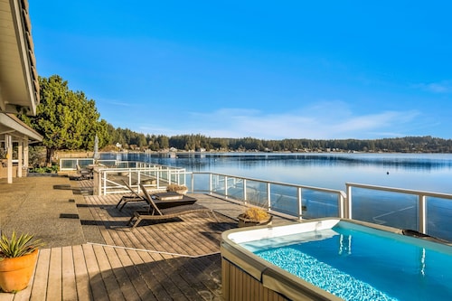 Waterfront home with private hot tub, game room with game tables, and water toys