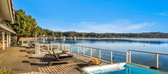 Waterfront home with private hot tub, game room with game tables, and water toys