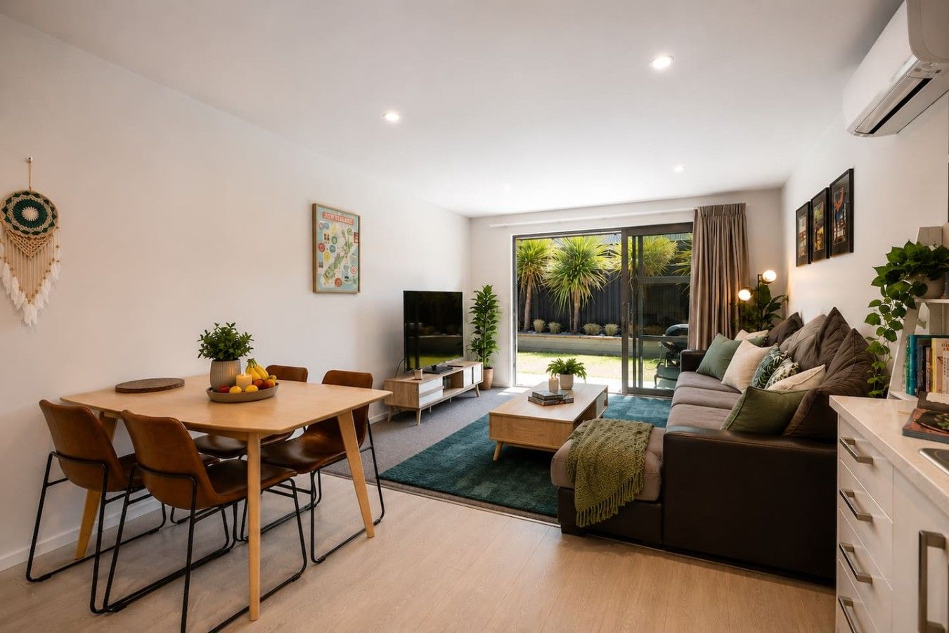 Un salon moderne comprenant un coin repas, un canapé, une table basse et un téléviseur.