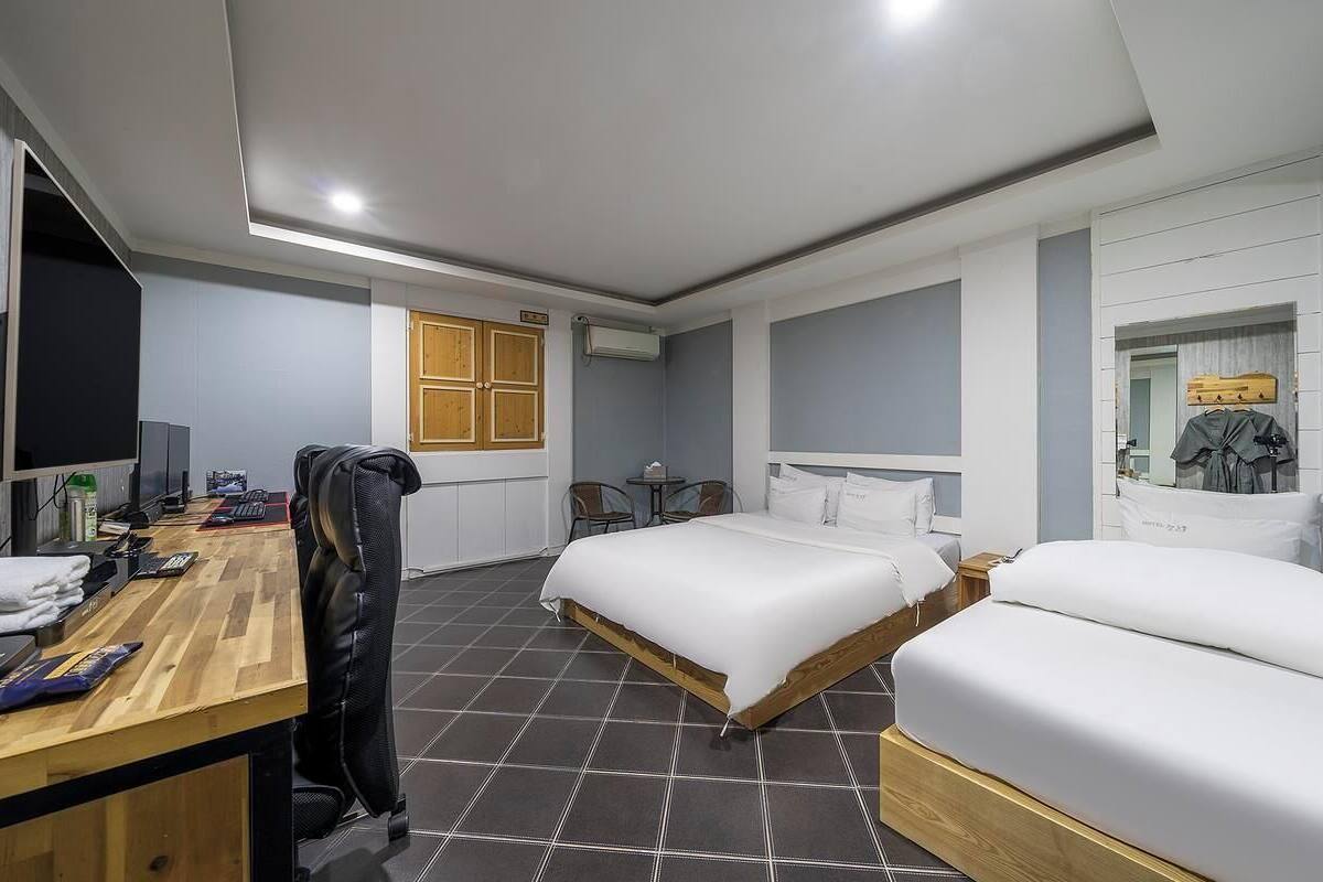 Ein Hotelzimmer mit Bett, Schreibtisch, Stuhl und kleinem Tisch.
