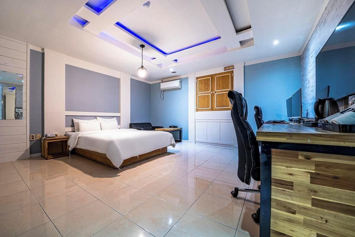 Ein modernes Hotelzimmer mit einem großen Bett, einem Schreibtisch und einem Stuhl.