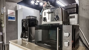 A kitchen with a coffee maker, a toaster, and a microwave. - Cat's Hotel (Bucheon)