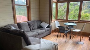 A living room with a grey sofa, a small round table, and two chairs.