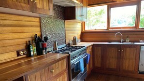 A kitchen with wooden cabinets, a stove, and a window.