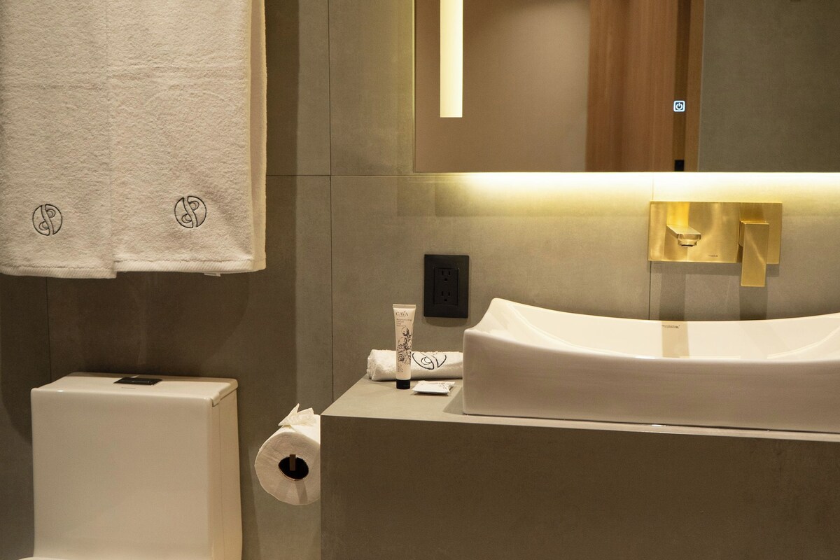 Ein modernes Badezimmer mit Toilette, Waschbecken und einem an der Wand hängenden Handtuch.