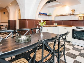 A dining area with a checkered floor, a dark wooden table, and black chairs with woven seats. - 4 Star Holiday Home in Skanderborg (Skanderborg)