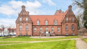 A large, historic brick building with symmetrical architecture, featuring multiple windows and a central entrance. - 4 Star Holiday Home in Skanderborg (Skanderborg)