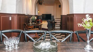 A dining area with a checkered floor, wooden chairs, a table with wine glasses, a basket, and a vase with flowers. - 4 Star Holiday Home in Skanderborg (Skanderborg)