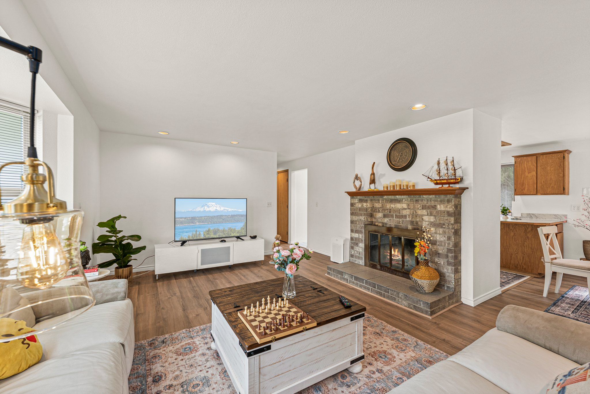 A modern living room with a fireplace, a television, and a chessboard.