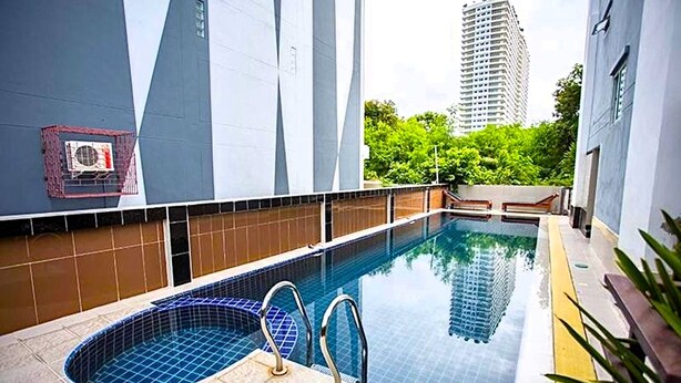 A swimming pool with a small hot tub, surrounded by tiled walls and a metal railing. - Corner Studio With Balcony Near Jomtien Beach - Beach Mountain 6 (Pattaya)