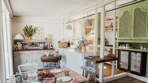 Eine gemütliche Küche mit Essbereich, ausgestattet mit einem Holztisch, Stühlen und einem Kühlschrank.