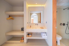 A modern bathroom with a freestanding sink, a mirror, and a shower area. - JamS Bali (Canggu)
