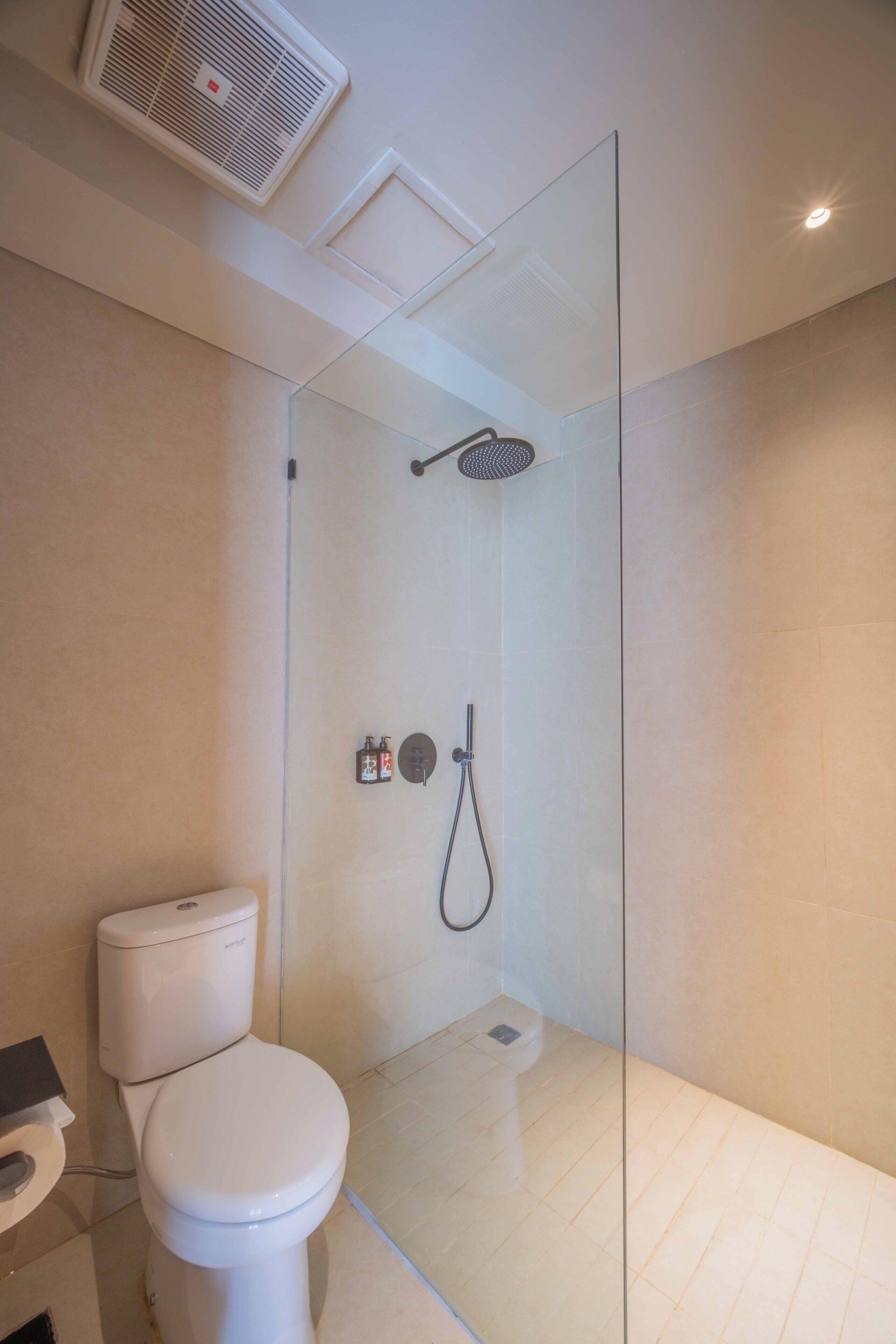 Un baño moderno con ducha envuelta en vidrio, inodoro y bidé.