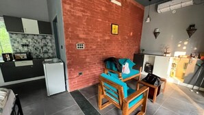 A compact living space with a kitchen area, a seating area with a blue sofa, and a small table.