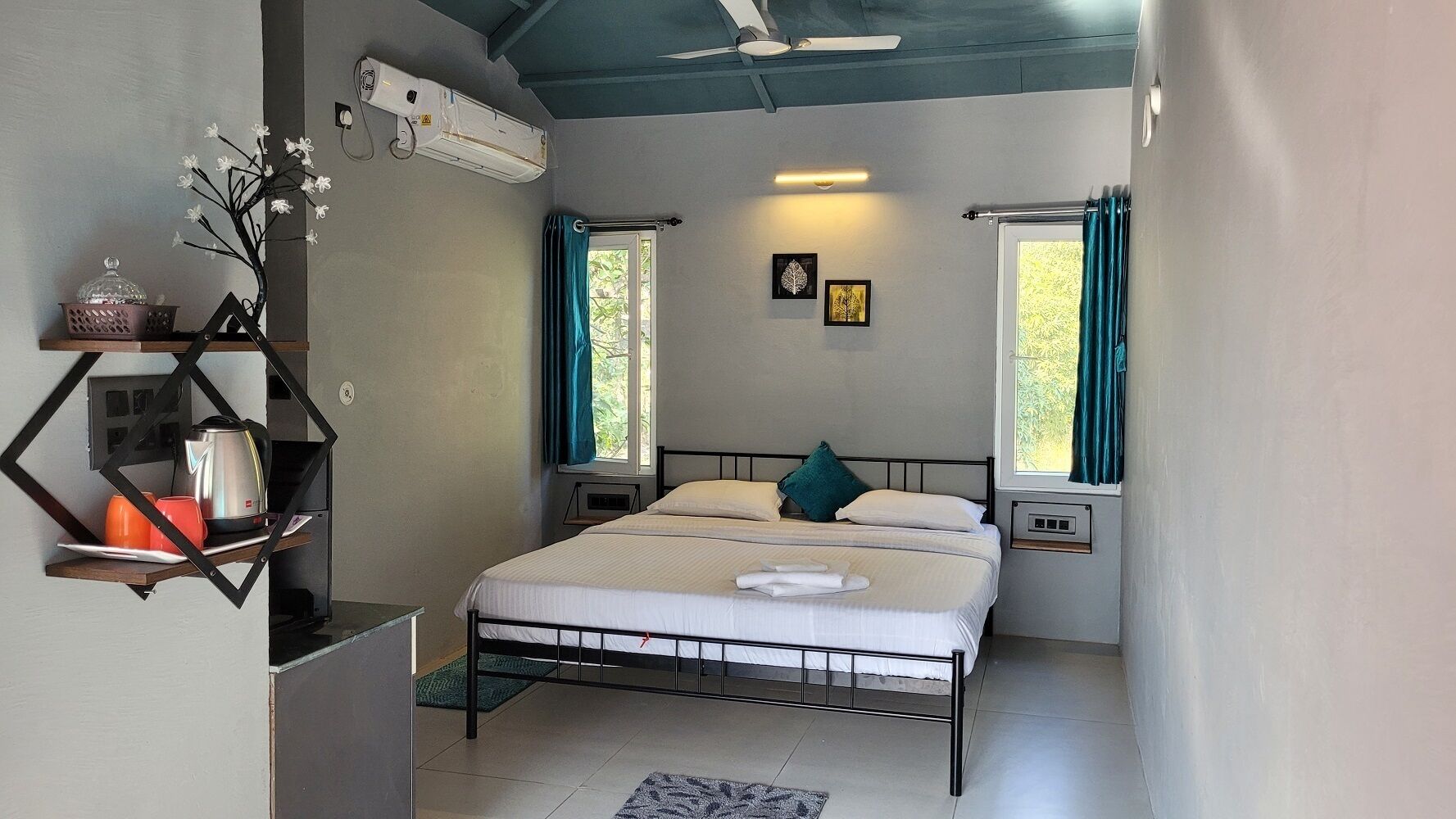 Un dormitorio con cama, una estantería con utensilios de cocina y una ventana con cortinas.