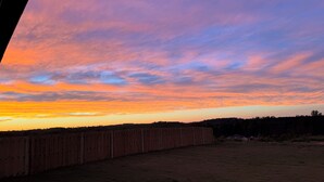 A sunset over a grassy field with a wooden fence in the foreground. - Modern 4-bedroom house for Masters Week (Grovetown)