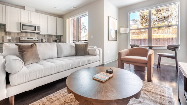 A modern living room with a sofa, a round coffee table, and a chair. - Blueground | Chevy Chase, rooftop, nr Rock Creek Park (Chevy Chase)
