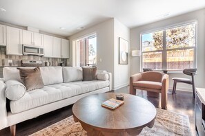 A modern living room with a sofa, a round coffee table, and a chair. - Blueground | Chevy Chase, rooftop, nr Rock Creek Park (Chevy Chase)
