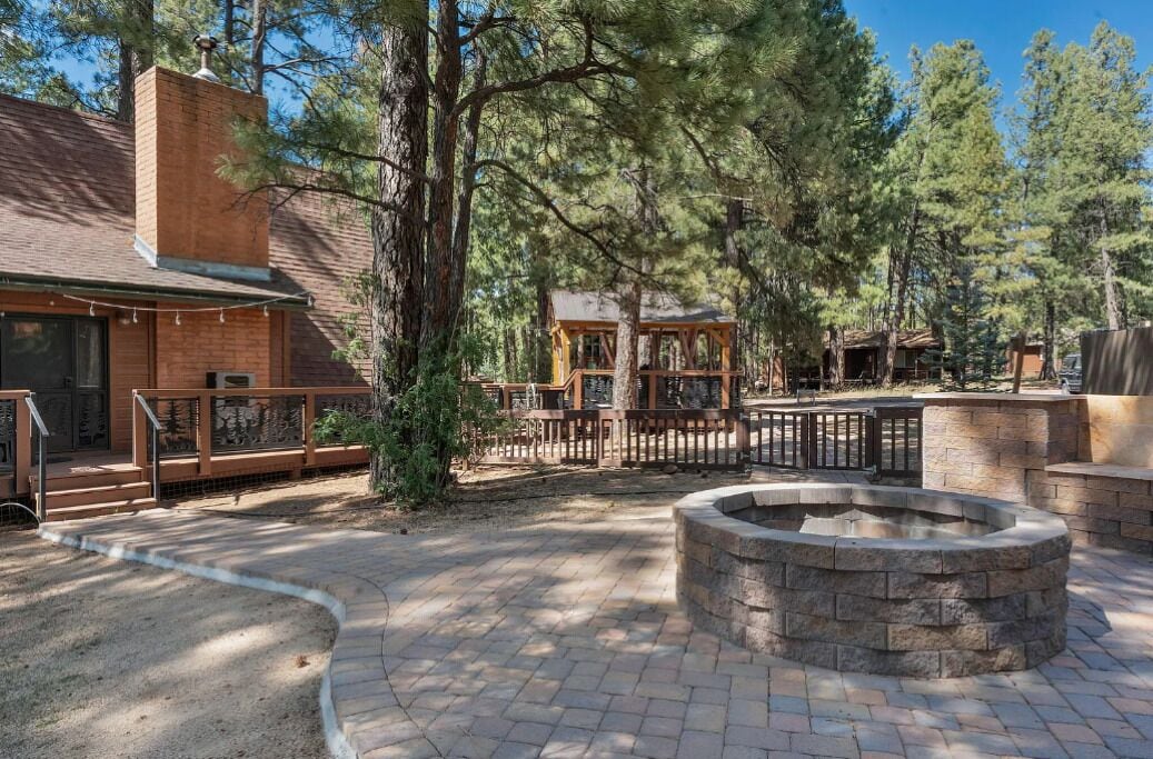 Un chalet rustique avec une façade en briques, une terrasse en bois et un foyer en pierre.