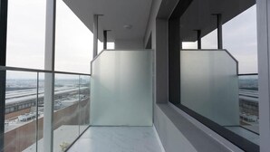 Un balcon moderne avec de grandes fenêtres, un sol en marbre et une vue sur un aéroport.