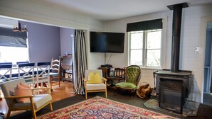 Una sala de estar con chimenea, televisor y una alfombra grande.
