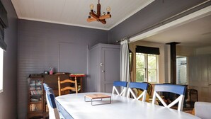 Un comedor con una mesa, sillas, un armario de madera y una estantería.