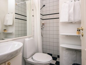 A bathroom with a toilet, a sink, a shower, and a mirror. - 4 Star Holiday Home in Skanderborg (Skanderborg)