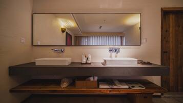 Un baño moderno con dos lavamanos, un espejo grande y un mueble de tocador de madera.