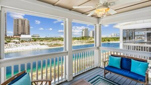 A covered outdoor area with a view of a beach and water, a ceiling fan, and a seating area with cushions. - New Listing! Lost Key Private Beach Club| 2 Swimming pools| Free Golf| Tennis| Bikes (Pensacola)