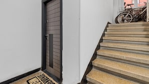 A staircase with a metal railing and a door with horizontal slats. - Apartament Lucas București  (Bucharest)