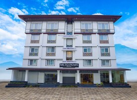 Un hotel de varios pisos con un cartel que dice "METO PEMA HOTEL".
