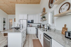 A modern kitchen with white cabinets, granite countertops, and stainless steel appliances. - Mtn-View 'Hidden Falls' Cabin w/ Hot Tub & Deck (Andrews)