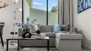 Ein modernes Wohnzimmer mit einem grauen Sofa, einem kleinen Tisch, einer Vase mit Blumen und einem Buch mit dem Titel "monochrome home".