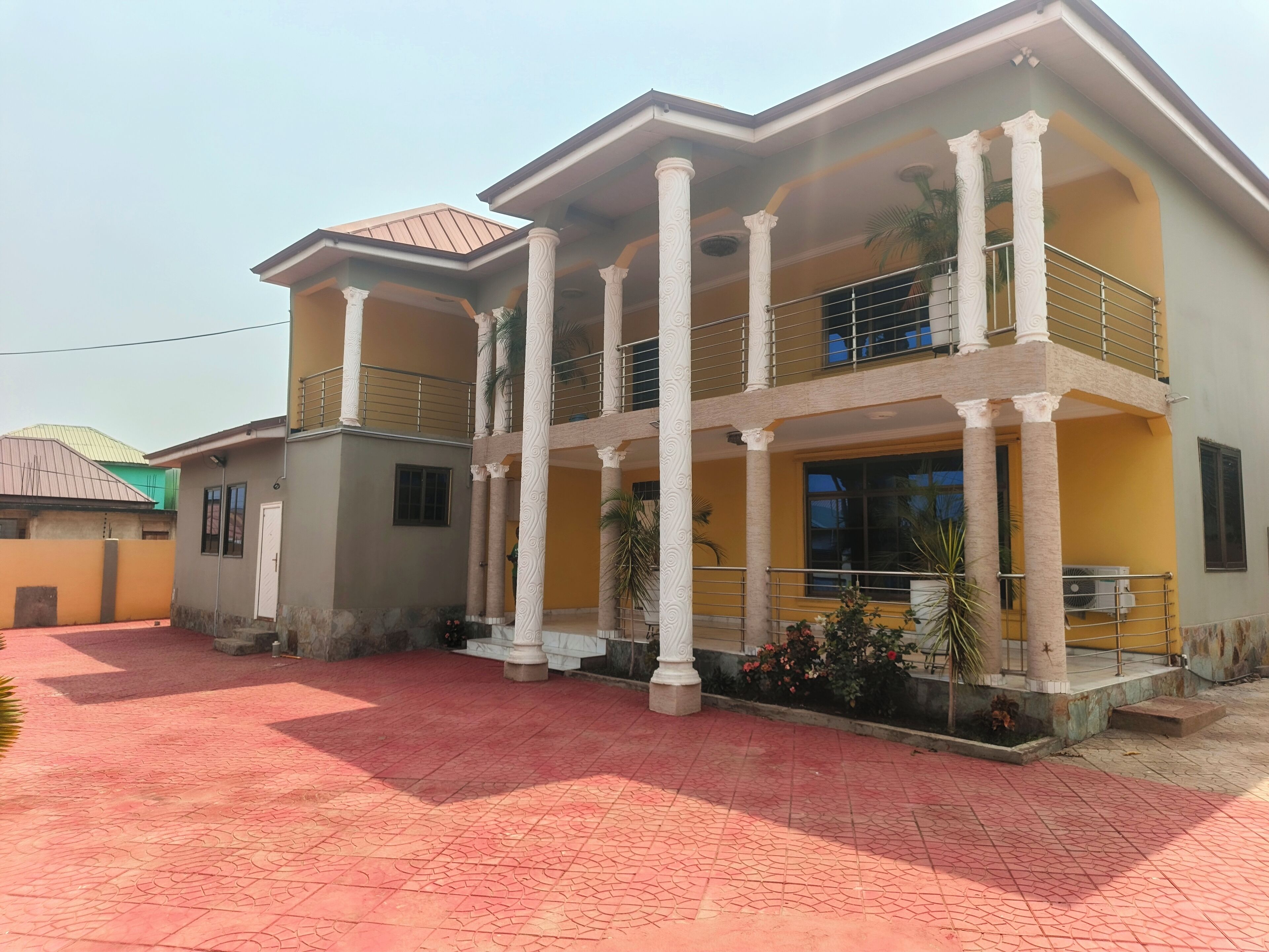 A two-story building with a balcony and a covered entrance.