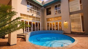 A hotel with a central pool, multiple balconies, and a brick patio. - Whistletree Luxury Manor (Pretoria)